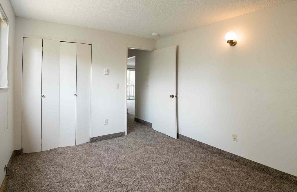 a bedroom with white walls and doors and carpet