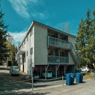 a white apartment building with cars parked in front of it
