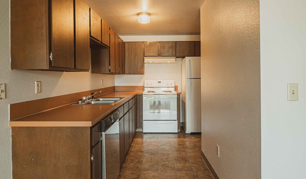 a kitchen with wooden cabinets and a white stove and refrigerator