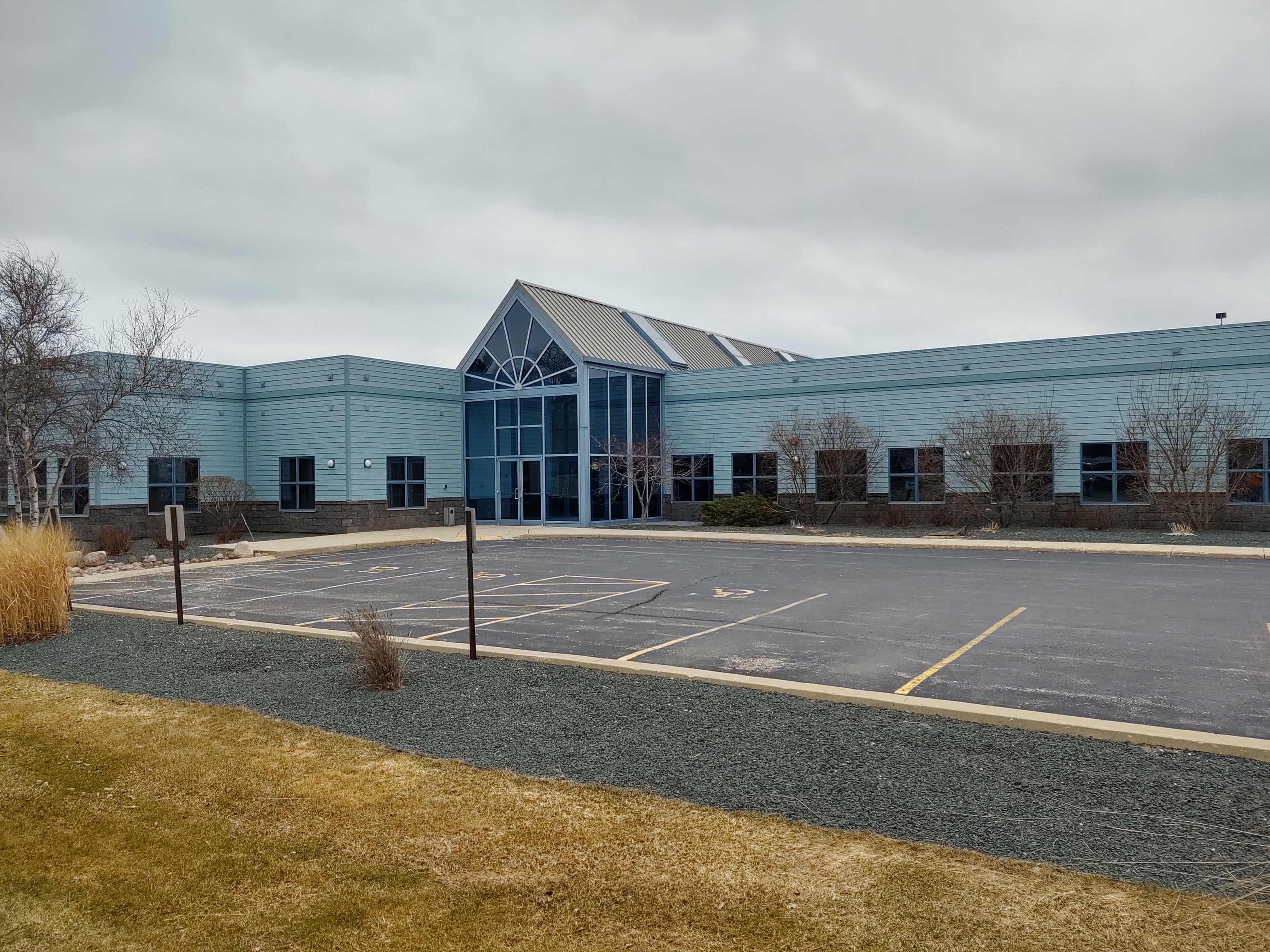 an empty parking lot in front of a blue building