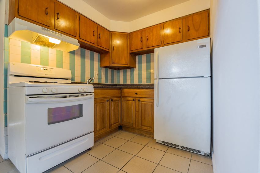 a kitchen with white appliances and wooden cabinets