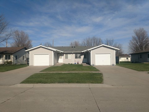 A house with a grey roof and two garages.