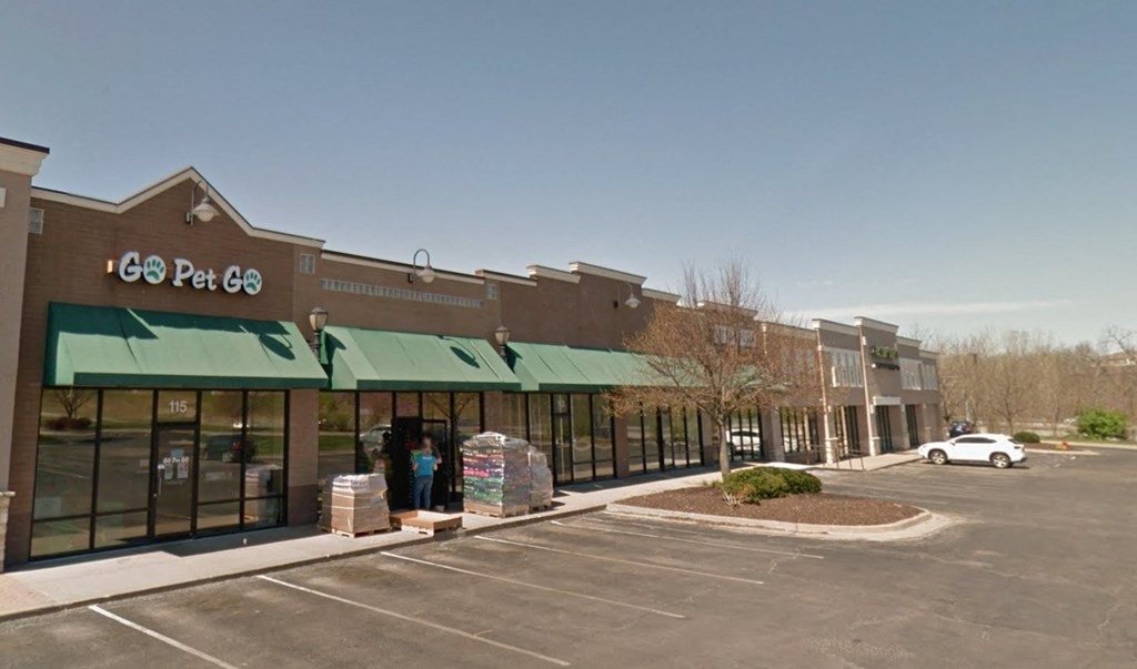 A storefront with a green awning and the name "Gos Pet Go" on it.