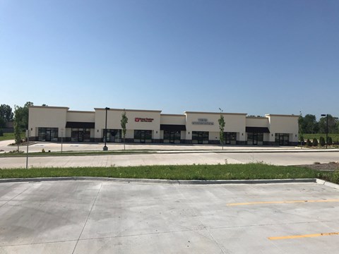 A large industrial building with a parking lot in front.