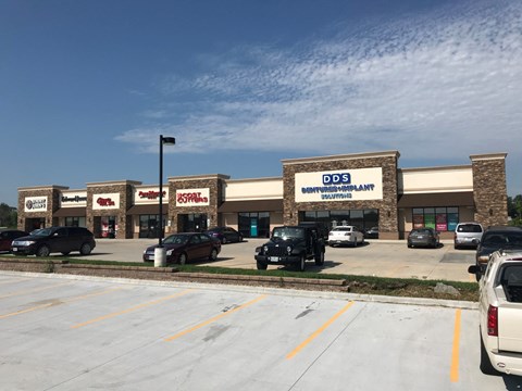 A parking lot with cars and a building that has a sign that says DDS SCHOOL PLANT.