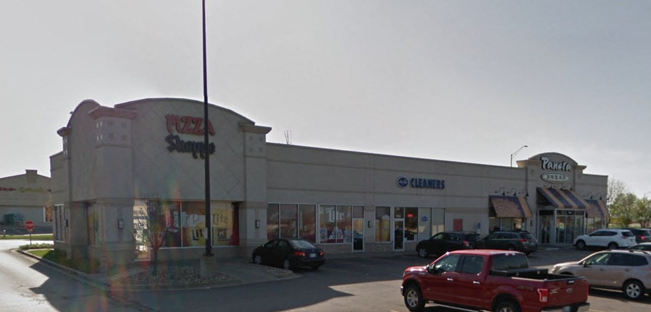 a shopping center with cars parked in front of it