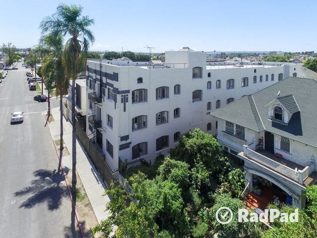 an aerial view of a white building and a street