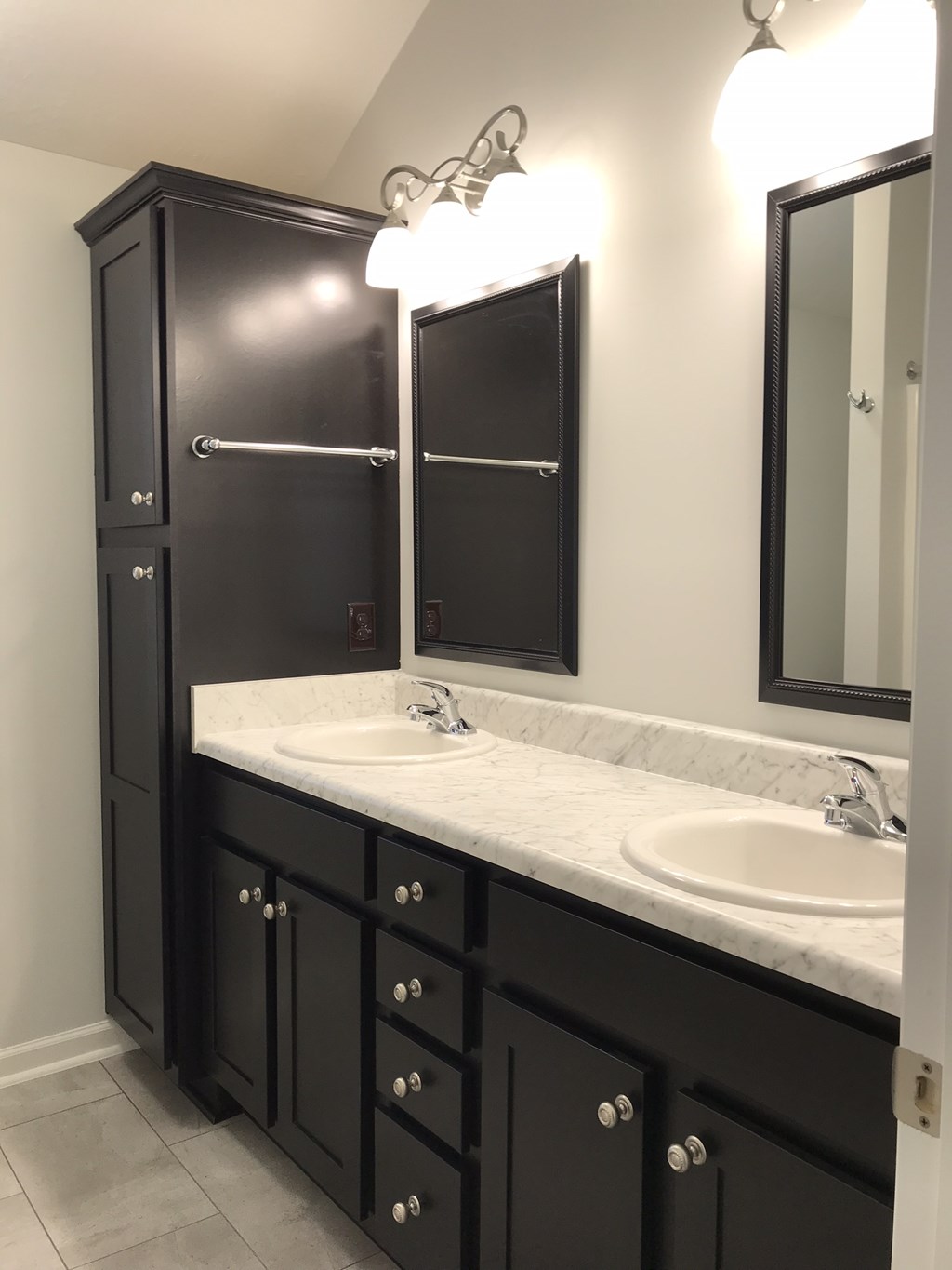 a black and white bathroom with two sinks and two mirrors