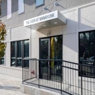 the front of a white building with a black fence