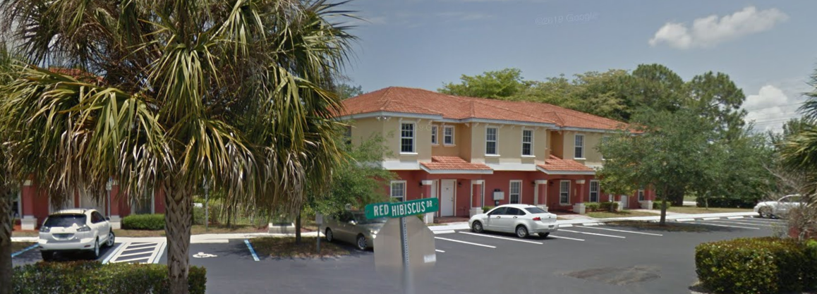 a screenshot of a street corner with a street sign