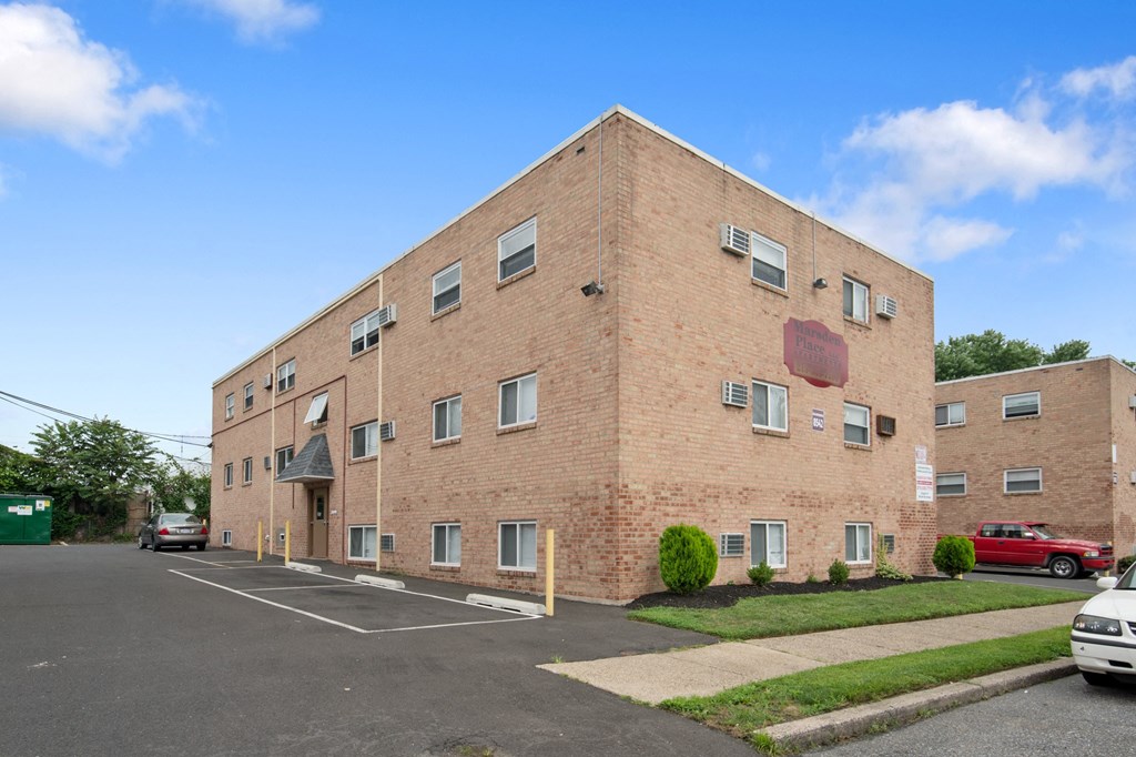 a brick apartment building with cars parked in front of it