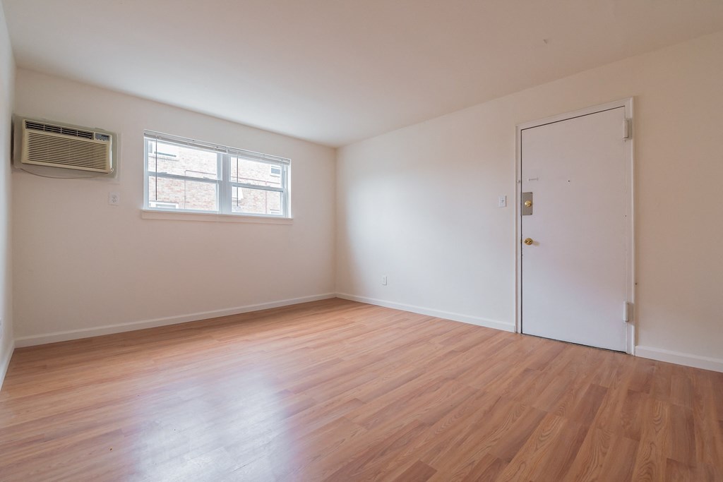 an empty living room with wood floors and a white door