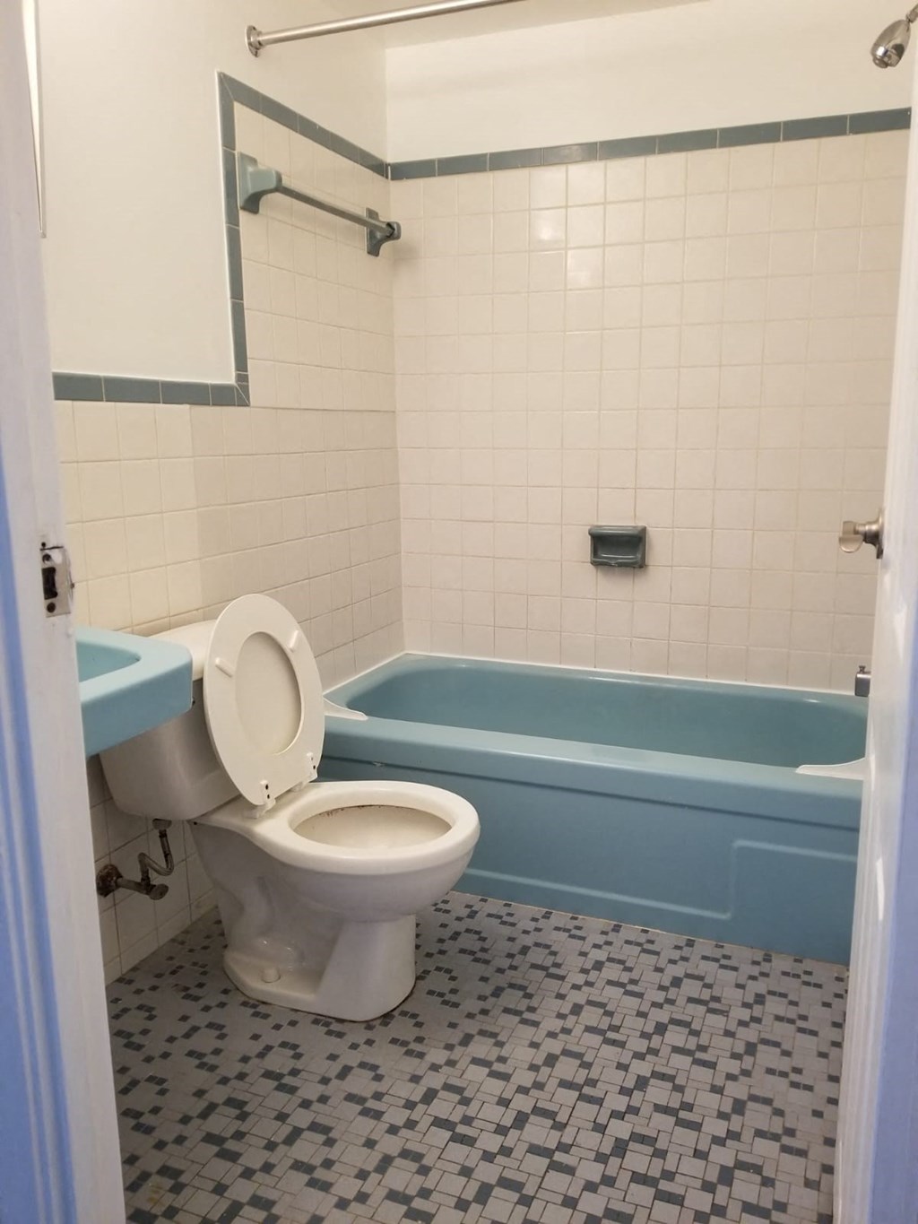 a bathroom with a toilet and a blue bath tub
