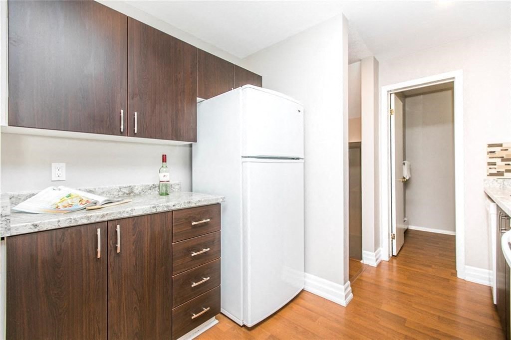a kitchen with a white refrigerator and wooden cabinets