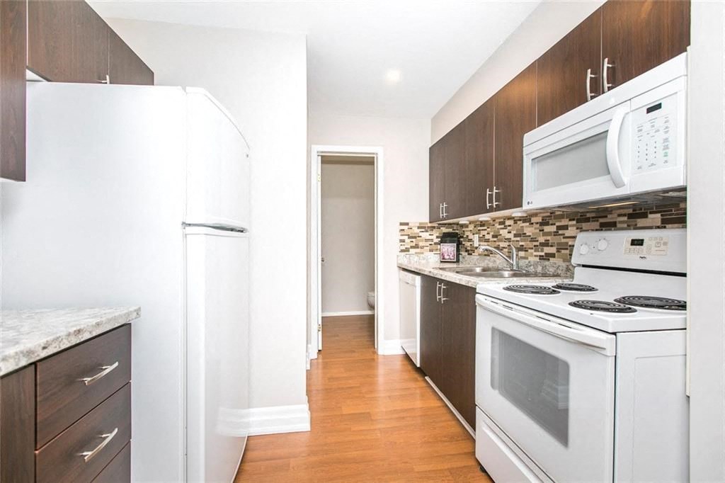 a kitchen with white appliances and wooden cabinets