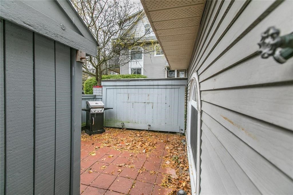 a back yard with a white fence and a garbage can