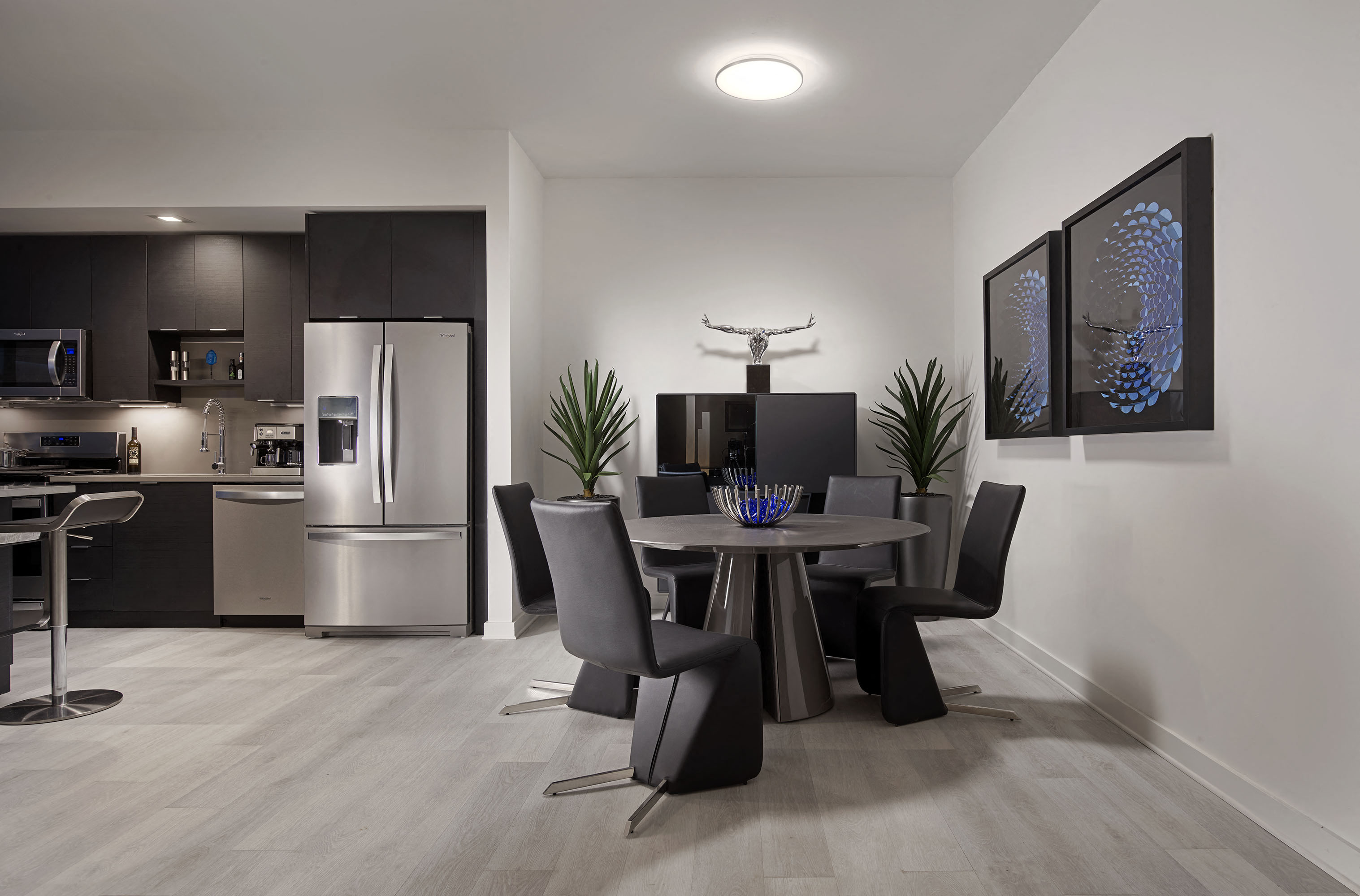 A modern kitchen with a dining table set for four.