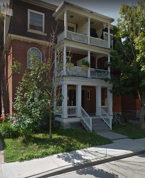 a red brick house with a white porch and stairs