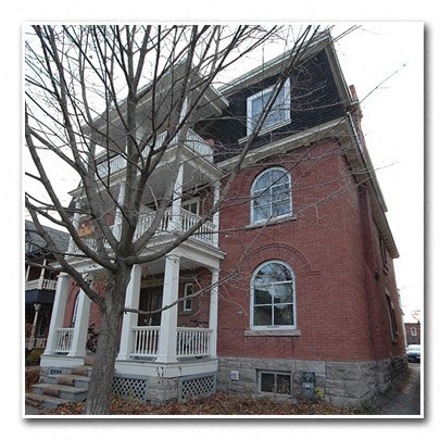 a red brick house with a tree in front of it