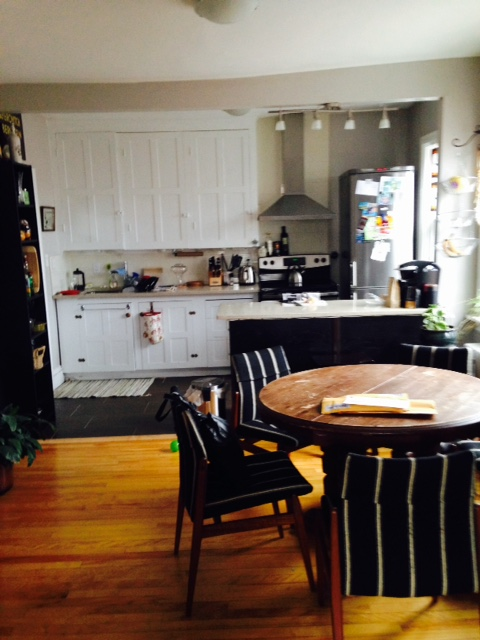 a kitchen with white cabinets and a table and chairs