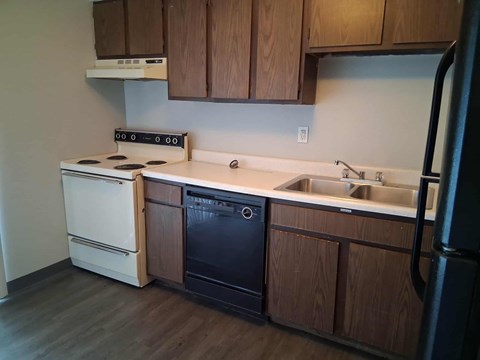 A kitchen with a white stove and black oven.