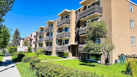 an apartment building with balconies and a sidewalk