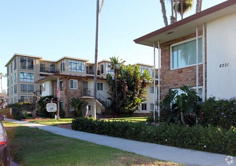 an apartment building with palm trees in front of it