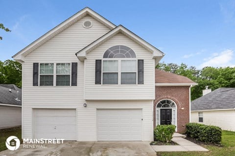 the front of a white house with a white garage door