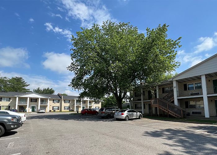 a parking lot with cars in front of apartment buildings