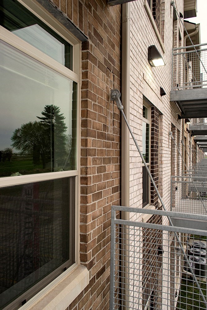 a brick building with a window and a fence
