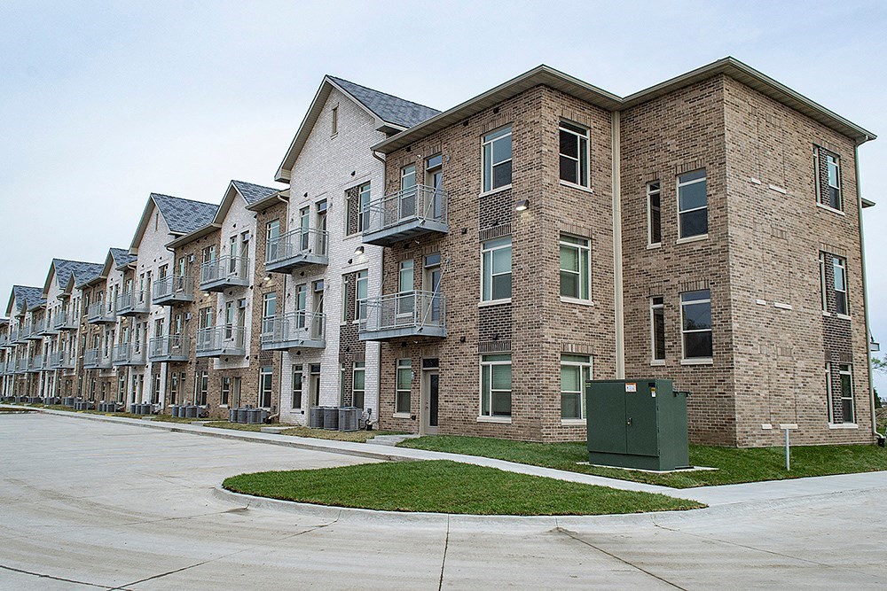 a row of brick apartment buildings on the side of a street