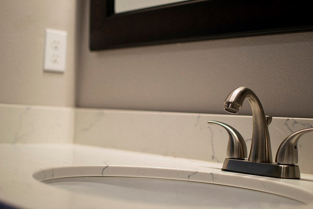 a bathroom sink with a faucet and a mirror