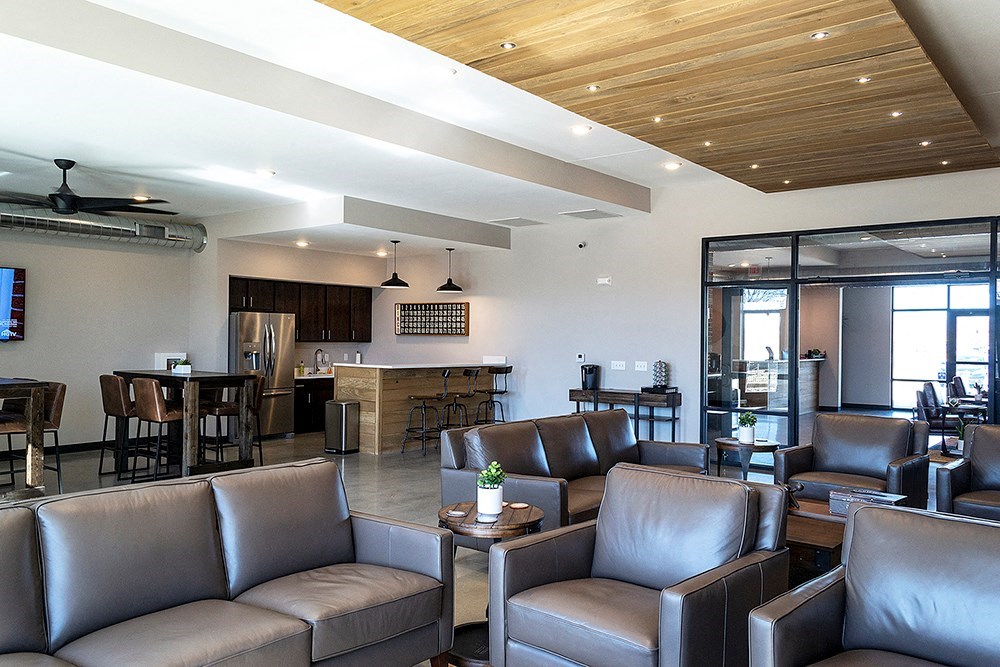 a living room with couches and chairs and a kitchen