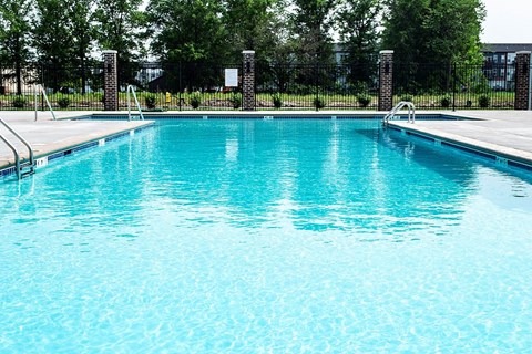 a large pool of water next to a fence