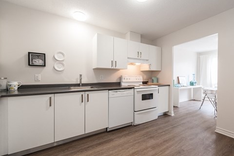 a kitchen with white cabinets and appliances and a dining room