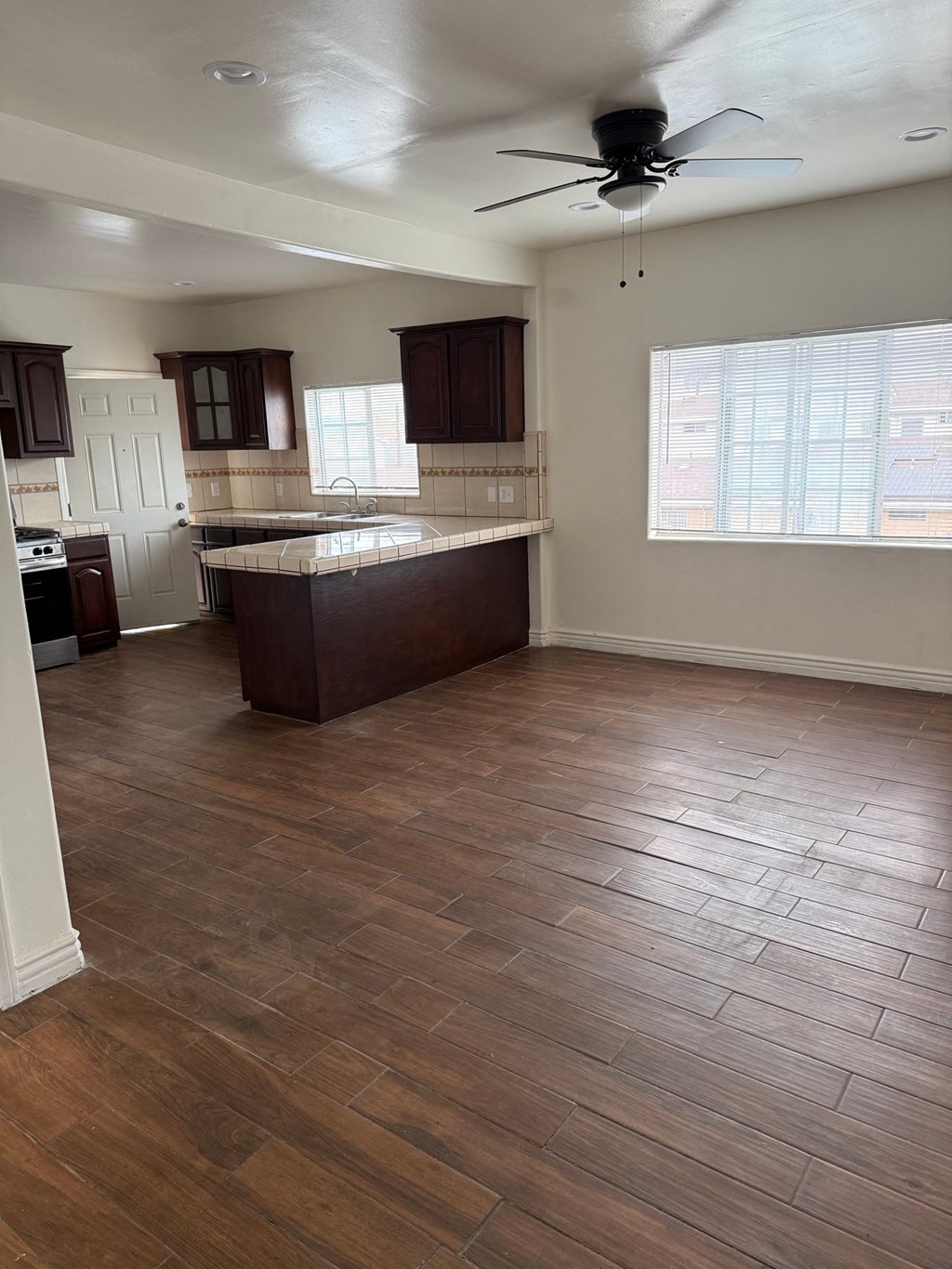 A kitchen with wooden floors and a ceiling fan.