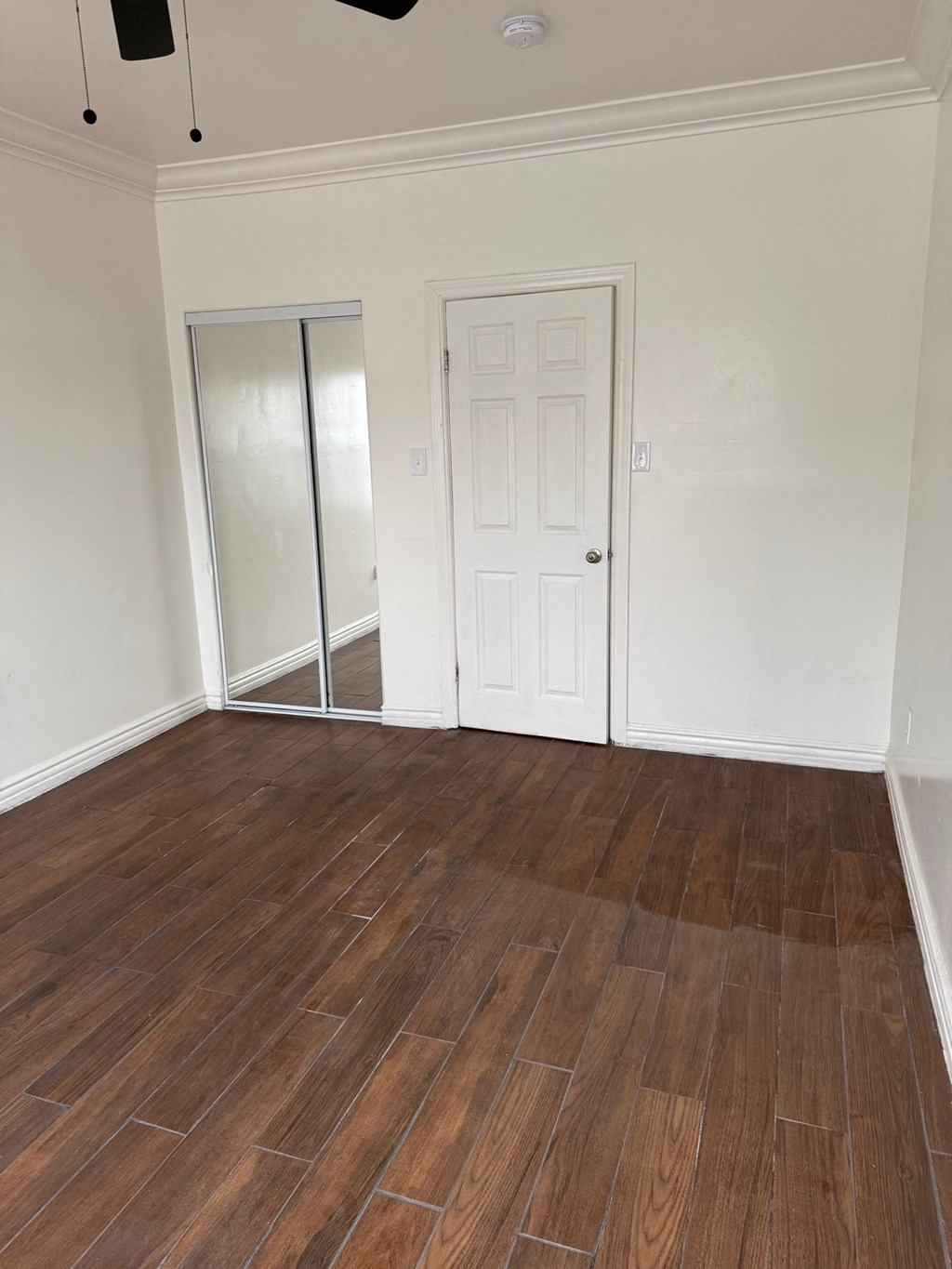 A room with a wooden floor and white walls.
