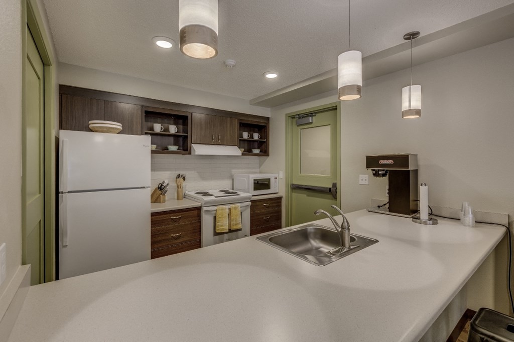 a kitchen with a white counter top and a sink