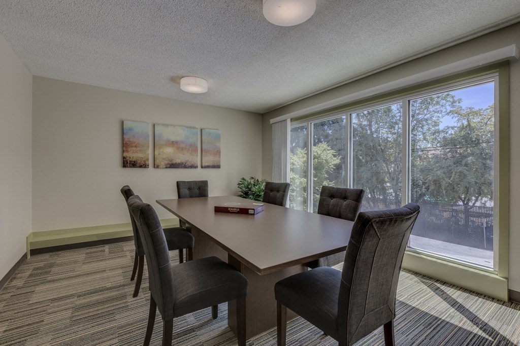 a conference room with a large window and a table with chairs