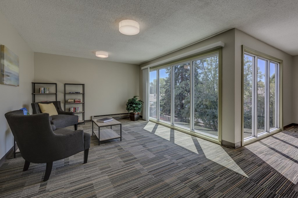 a living room with large windows and a couch and chair