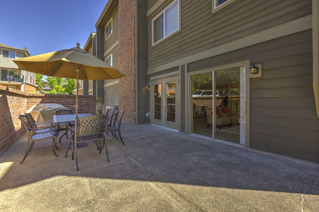 a patio with a table and chairs and an umbrella