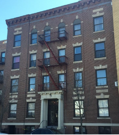 A red brick building with a fire escape on the side.