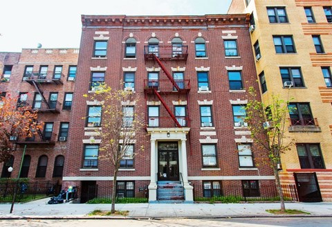 A red brick building with a black door and windows.