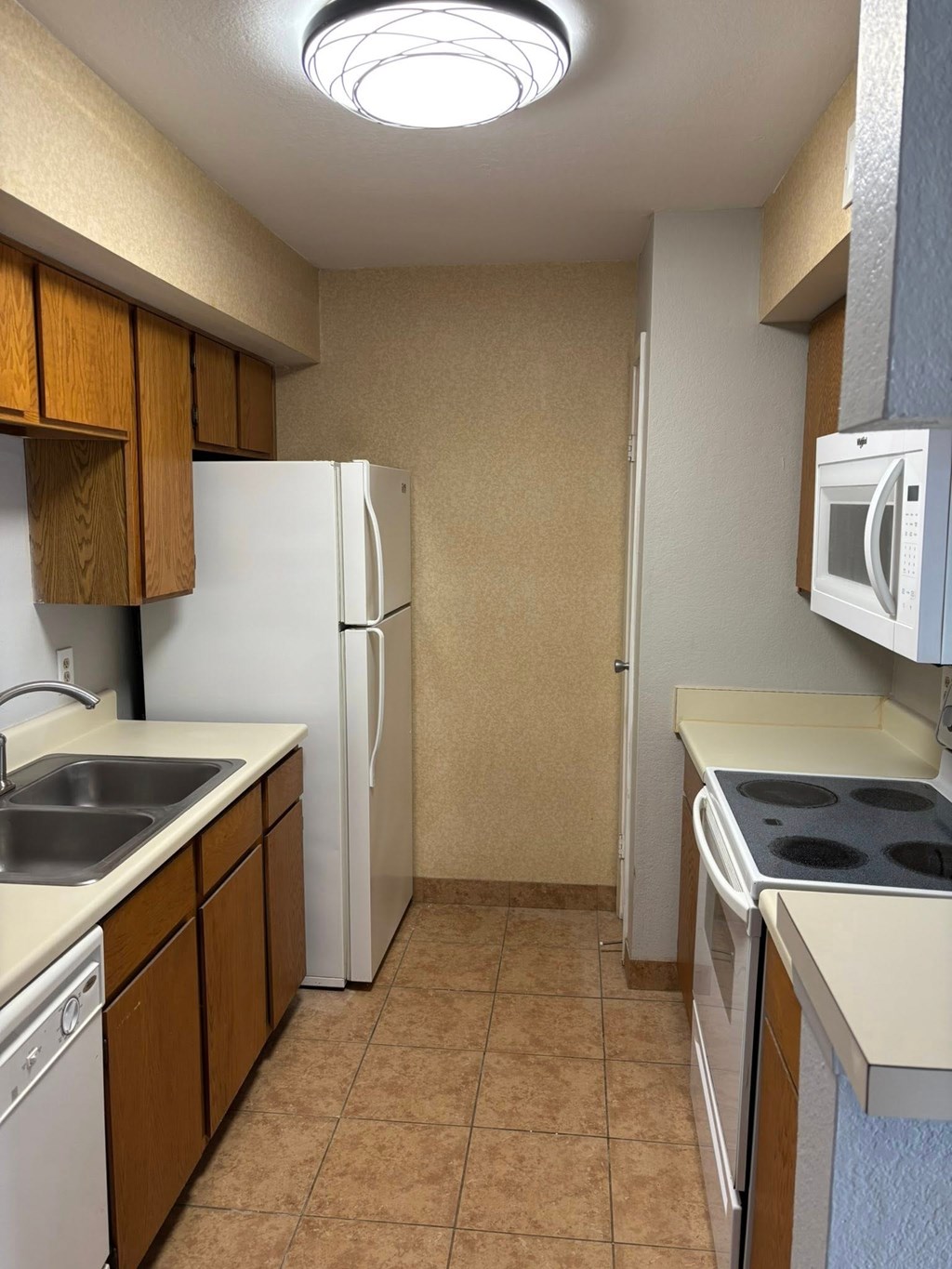 A kitchen with a white refrigerator and a white microwave.