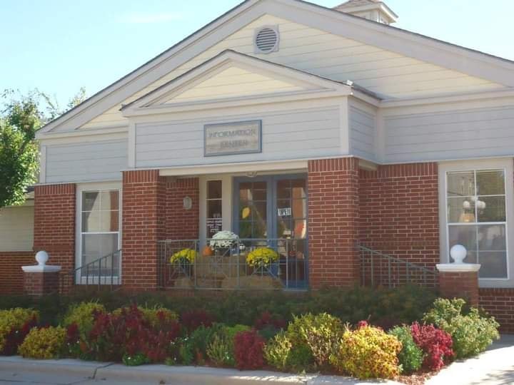 A small white building with a red brick base and a sign that reads "Harmonium".