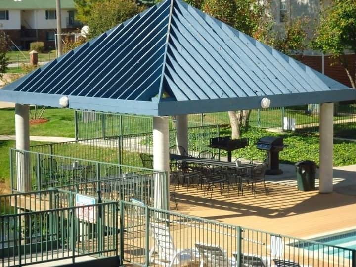 A blue and white striped patio umbrella is open over a table and chairs.