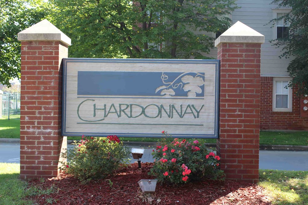 A sign that says Chardonnay in front of a building.