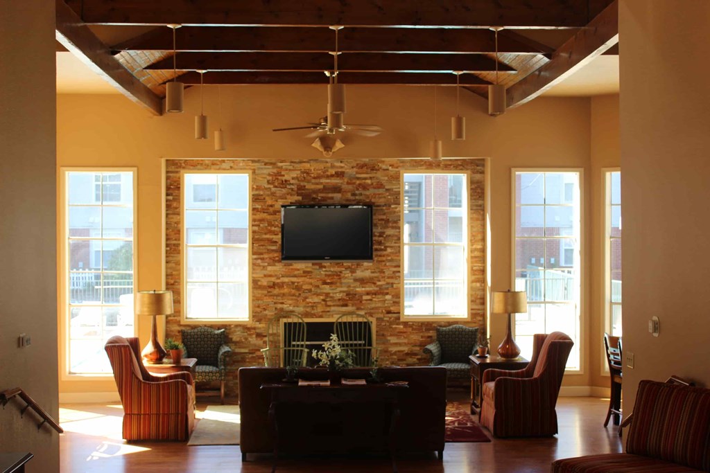 A living room with a fireplace and a television on the wall.