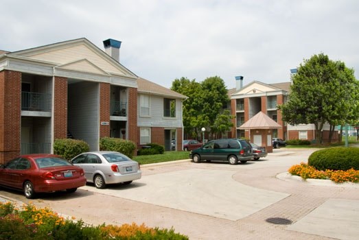 A red car is parked in front of a building.