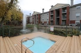 A small pool with a fountain in the middle of a wooden deck.